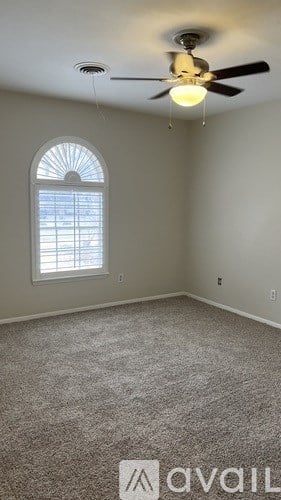 A room with a ceiling fan and a window with blinds.