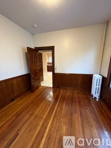A room with wooden floors and a white radiator.