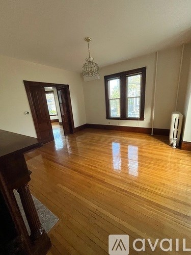 A room with wooden floors and a chandelier.