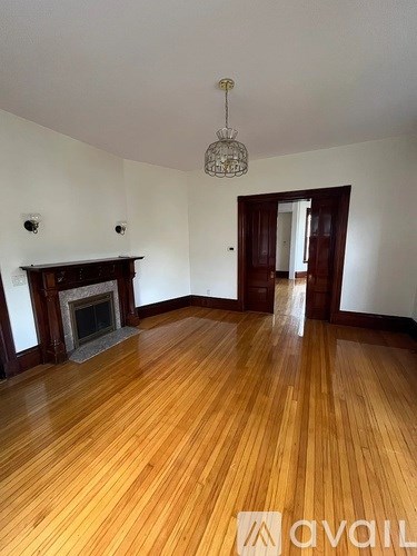 A room with wooden floors and a fireplace.