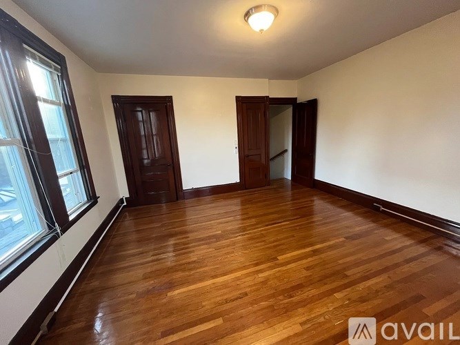 A room with wooden floors and two doors.