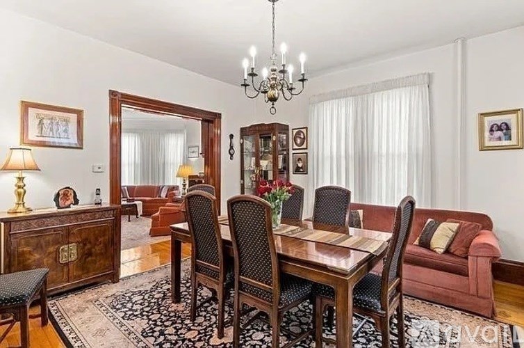 A dining room with a wooden table and chairs.
