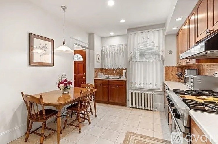 A kitchen with a table and chairs in the middle of the room.