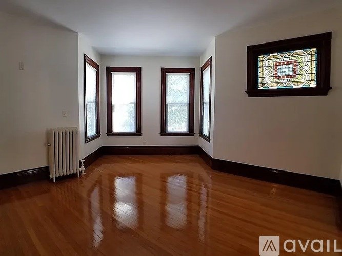 A room with wooden floors and a stained glass window.