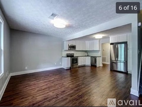 A spacious kitchen with white cabinets and stainless steel appliances.