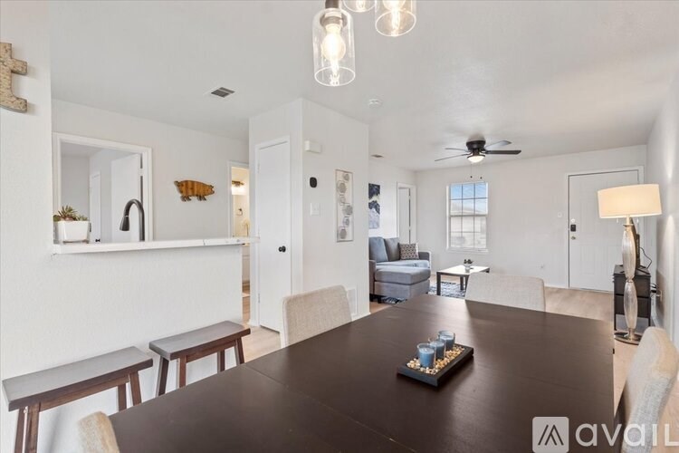 A modern dining room with a dark wooden table and chairs.