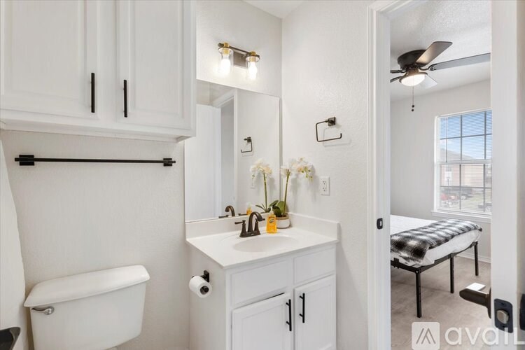 A bathroom with white cabinets and a white toilet.