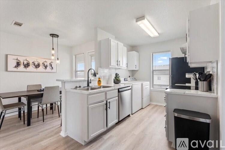A kitchen with white cabinets and a wooden floor.