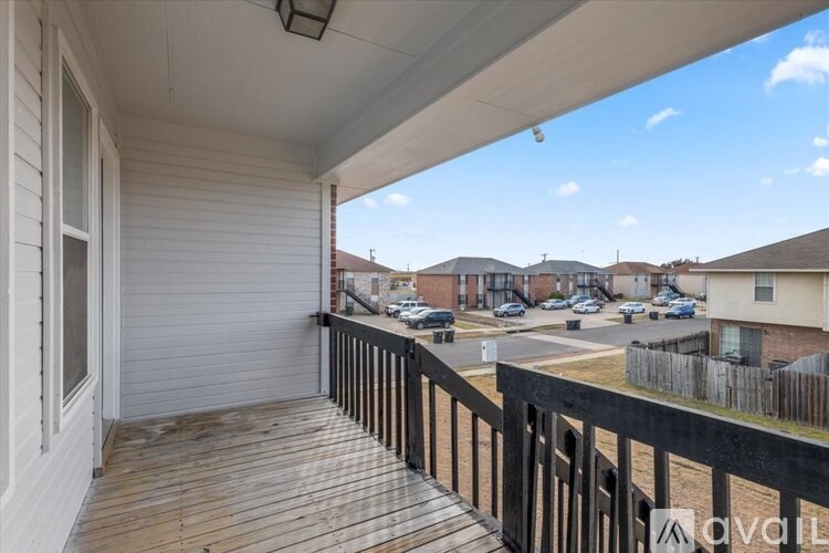 A balcony with a black railing and a white wall.
