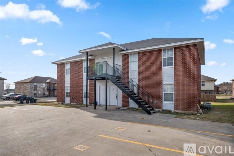 A red brick house with a white door and a black staircase.