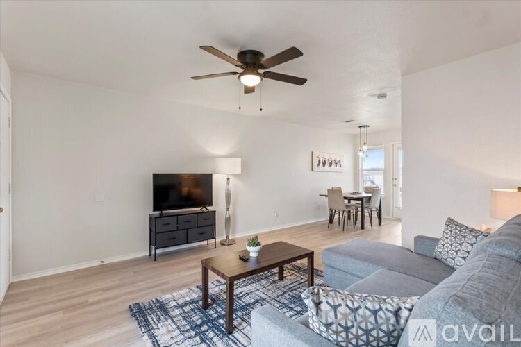 A living room with a grey couch and a wooden coffee table.