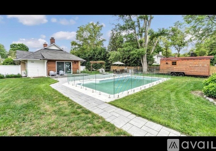 A backyard with a pool and a house.
