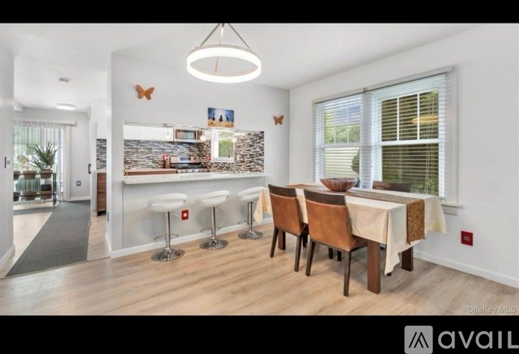 A dining room with a table set for four and a view of the backyard.
