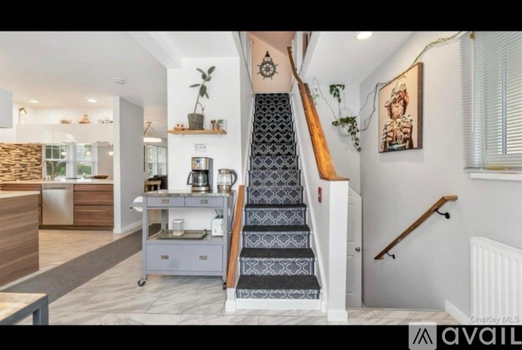 A staircase with a patterned runner leads to a second floor.