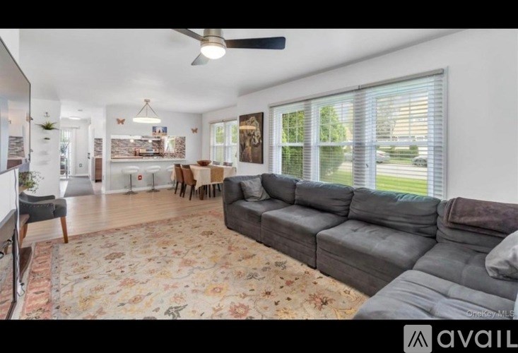 A living room with a grey couch and a rug with a floral pattern.