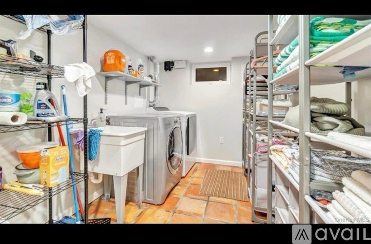 A laundry room with a washer and dryer, and a shelf with various items.