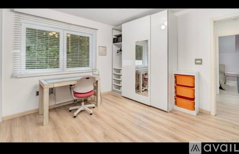 A room with a desk and a chair in it.