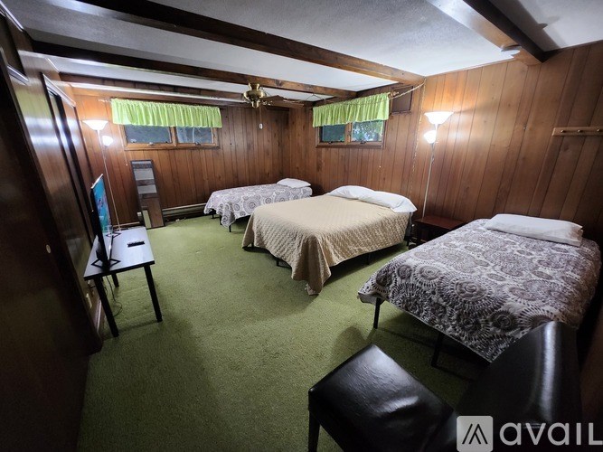 A bedroom with two beds and a chair.