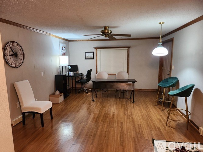 A room with a wooden floor and a ceiling fan.