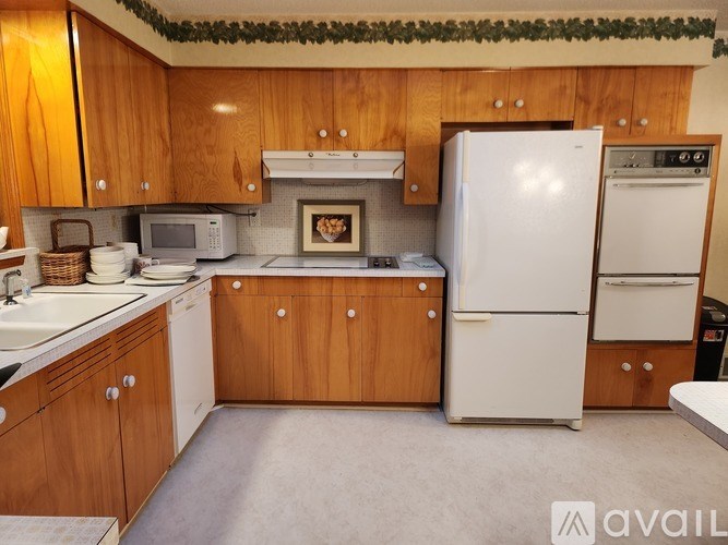 A kitchen with wooden cabinets and a white refrigerator.