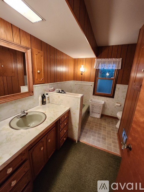 A bathroom with wooden cabinets and a white sink.