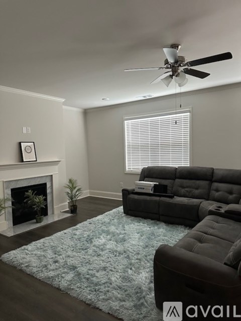 A living room with a fireplace, a sofa, and a rug.