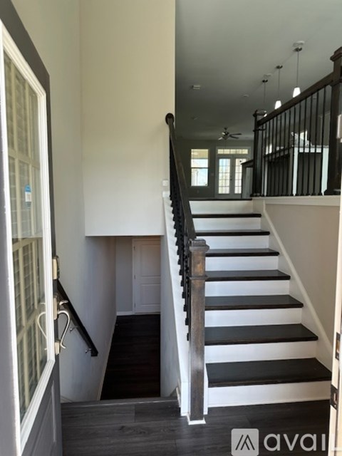 A staircase with a black railing and white steps.