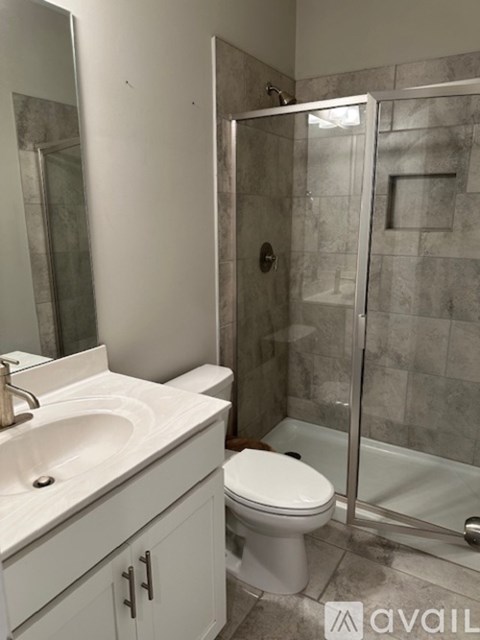 A bathroom with a toilet, sink, and shower.