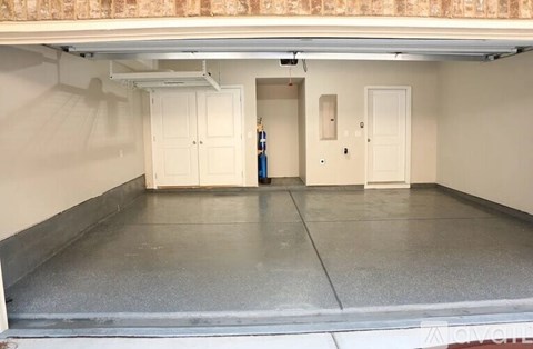 A spacious room with a grey floor and white walls.