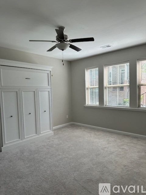 A room with a ceiling fan and a cabinet.