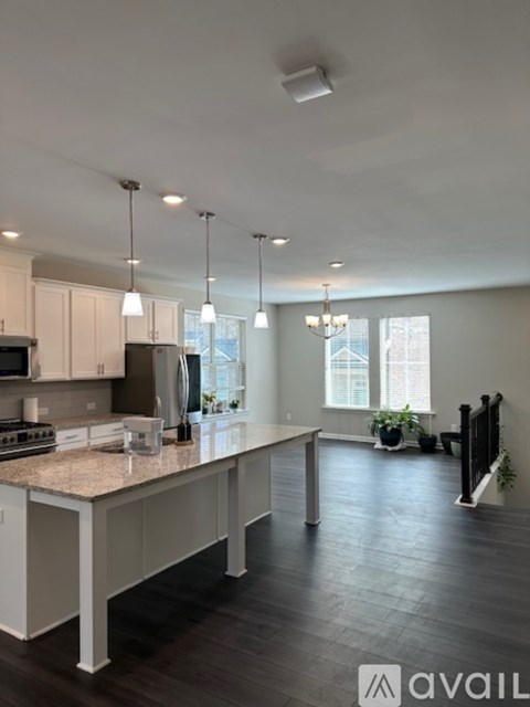 A kitchen with a granite countertop and a large island.