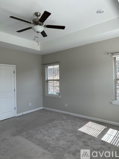 A room with a ceiling fan and a window.