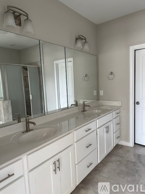 A bathroom with two sinks and a large mirror.
