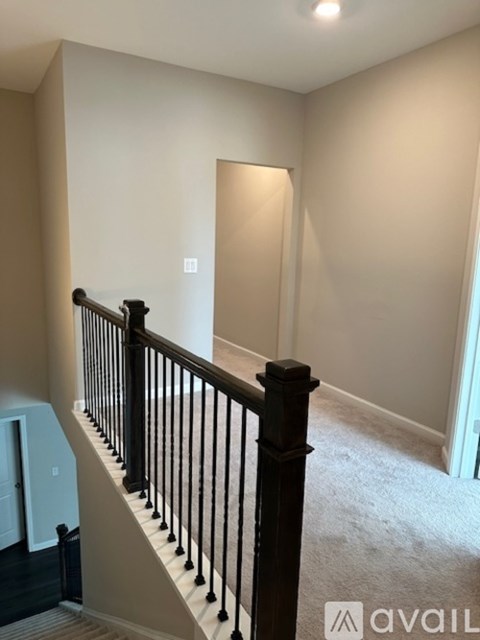 A staircase with a black railing and a carpeted floor.