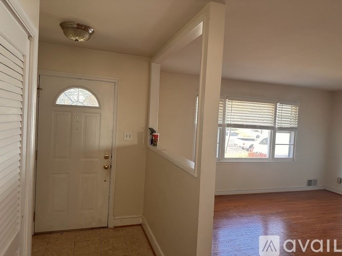 A room with a door and a window with blinds.