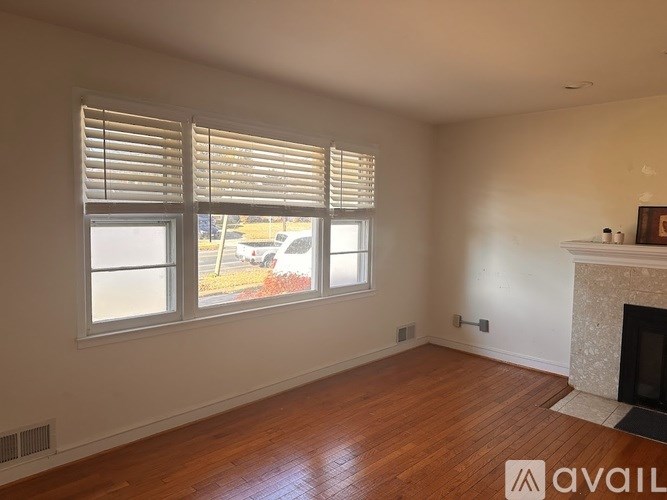 A room with a fireplace and a window with blinds.