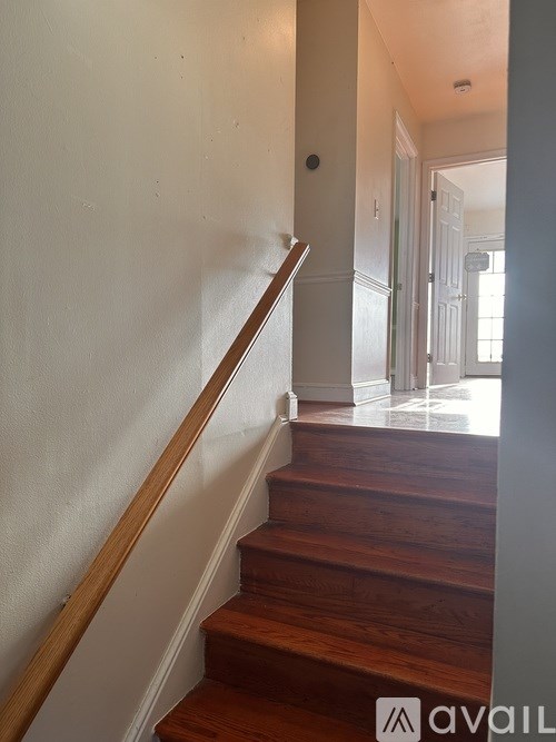 A wooden staircase with a white wall on the side.