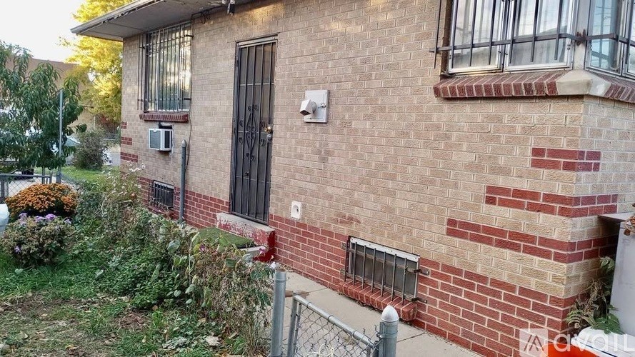 A brick house with a black door and a small window.