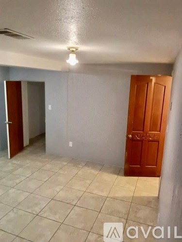 A room with a tiled floor and a wooden door.