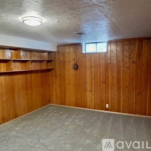 A room with wooden walls and a window.