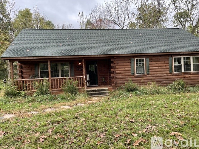 A small wooden cabin with a green roof and a porch.
