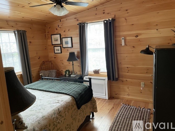 A bedroom with a bed, nightstand, and a ceiling fan.