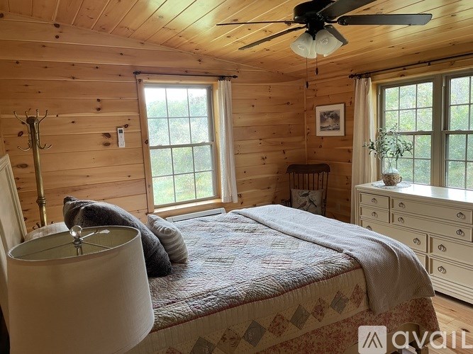 A bedroom with a bed, dresser, and ceiling fan.