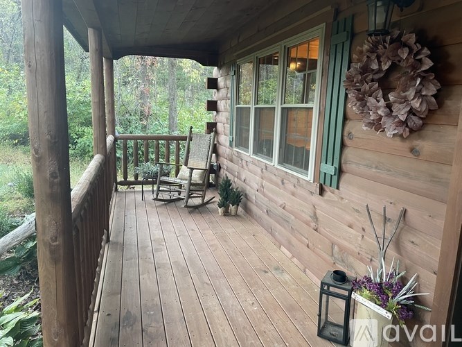 A wooden porch with a wreath and a lantern.
