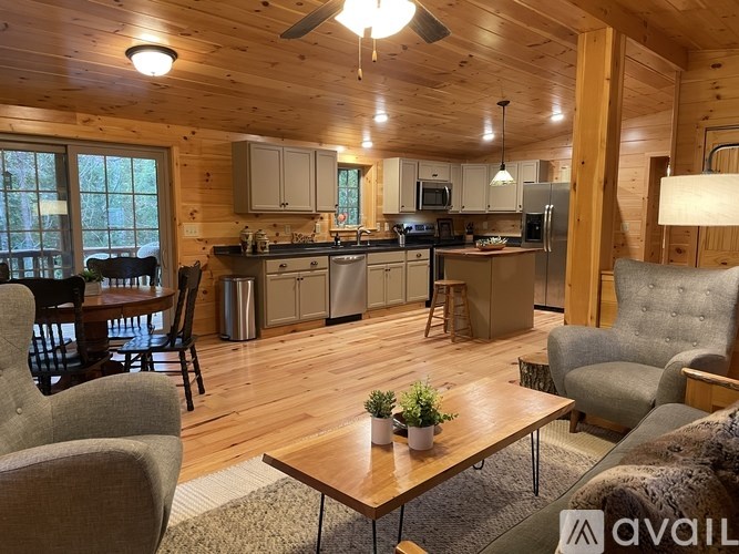 A wooden kitchen and living room with a table and chairs.