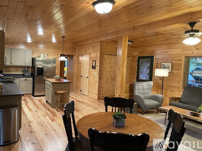 A wooden cabin with a table and chairs in the middle of the room.