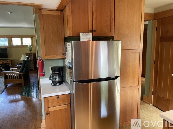 A stainless steel refrigerator in a kitchen with wooden cabinets.