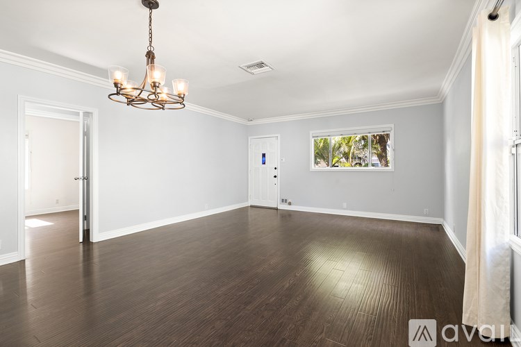 A large empty room with a chandelier hanging from the ceiling.