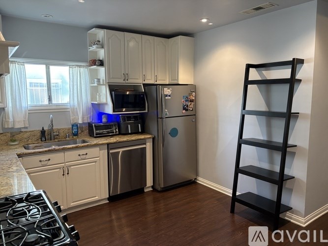 A kitchen with a refrigerator, microwave, and oven.