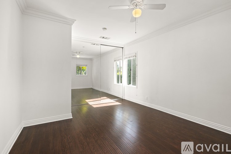 A spacious room with wooden floors and white walls.